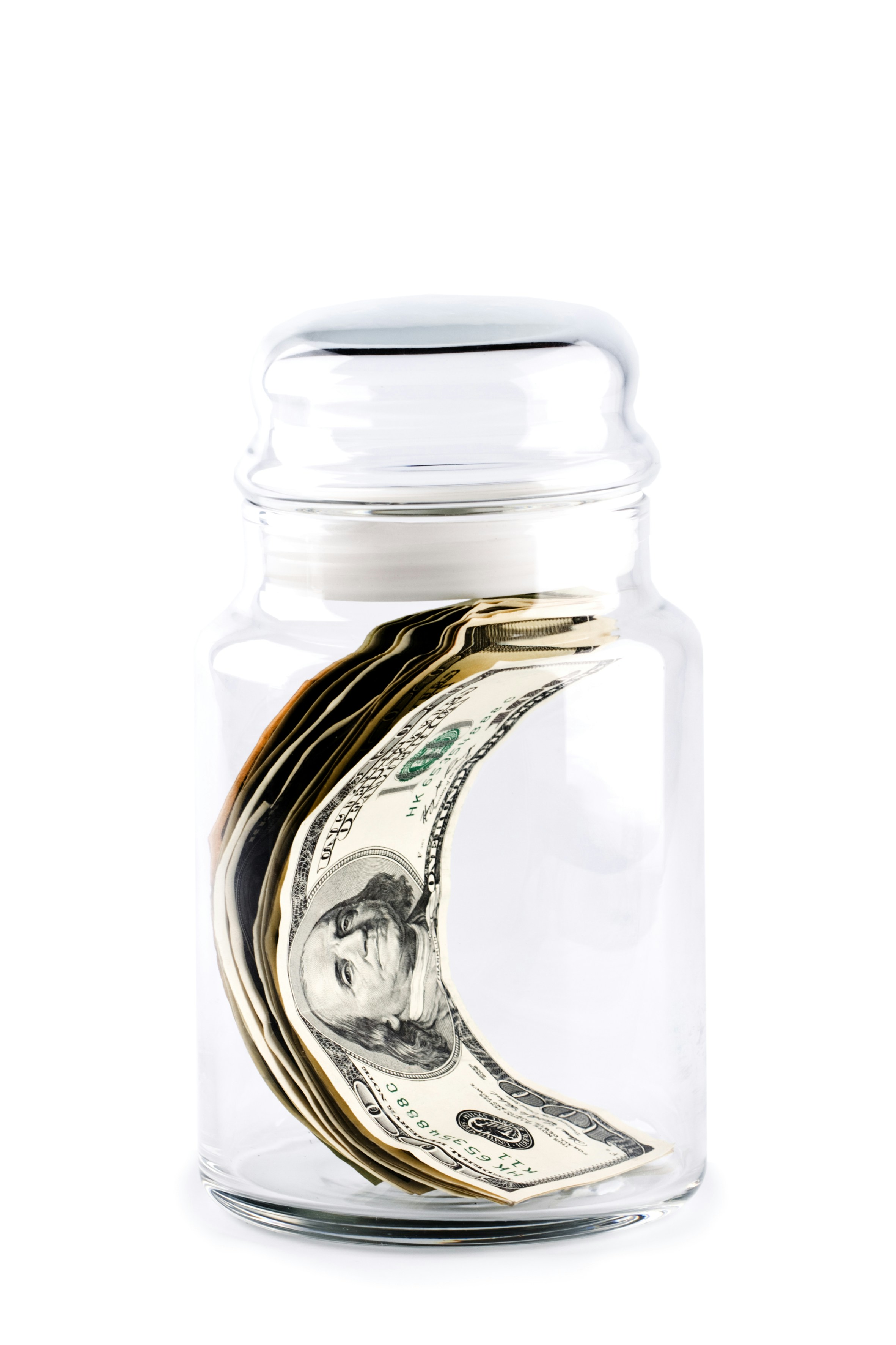 A jar filled with money sitting on top of a table